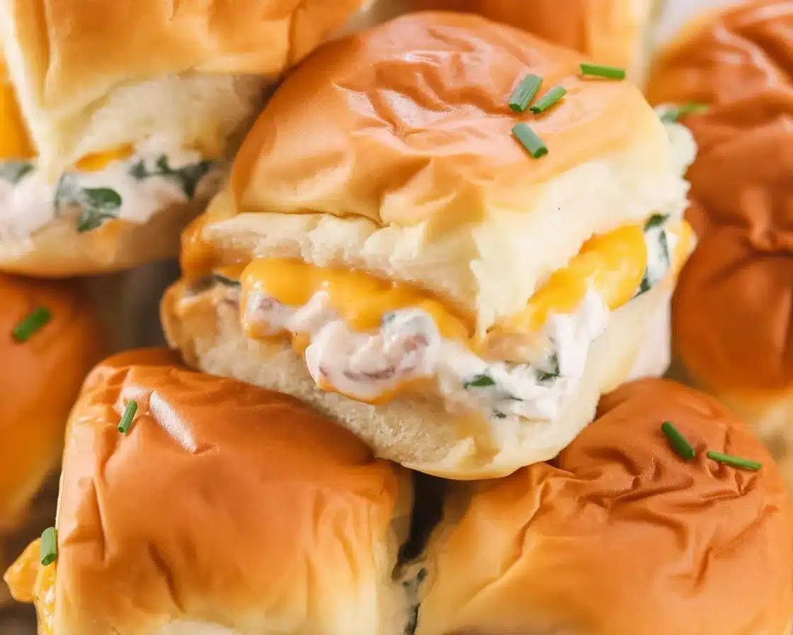 A delicious plate of creamy Crack Chicken Sliders on Hawaiian rolls topped with bacon.