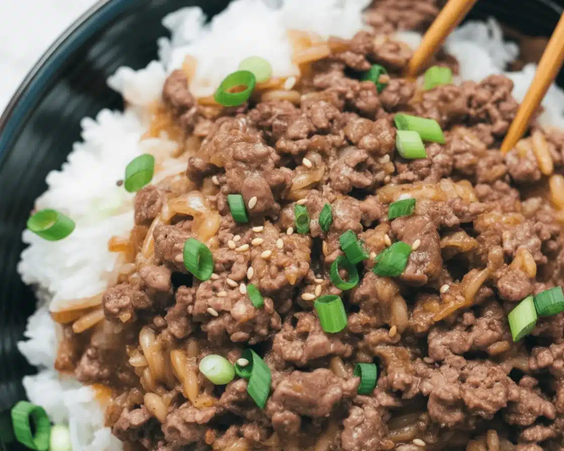 A delicious Korean Ground Beef Bowl served over rice with green onions and sesame topping.