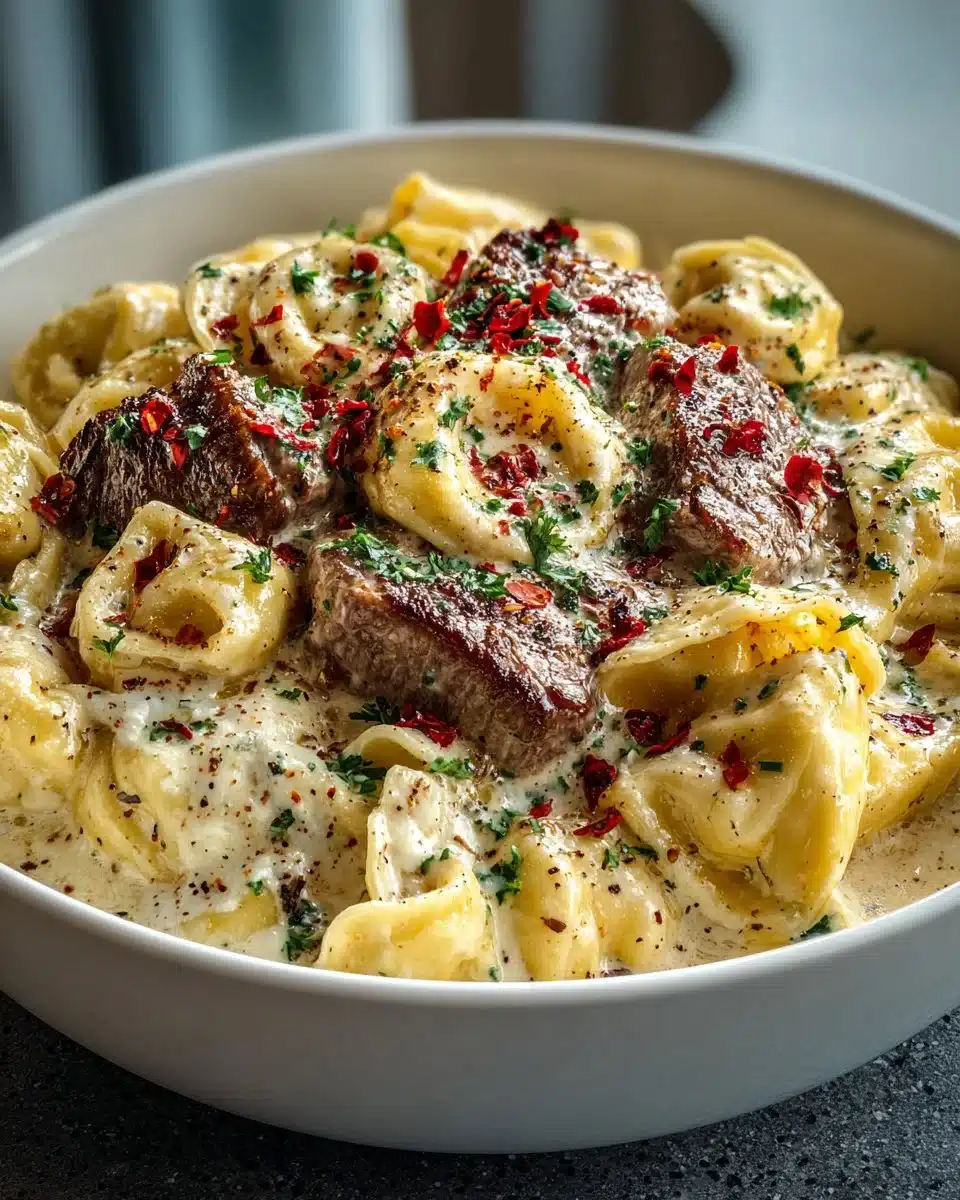 Cracked garlic steak tortellini in creamy sauce garnished with herbs