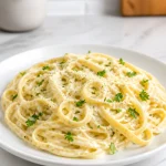 Creamy homemade garlic parmesan pasta with herbs and cheese